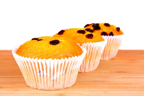 Muffins με σταφίδες σε ξύλινη επιφάνεια που απομονώνονται σε λευκό — Φωτογραφία Αρχείου