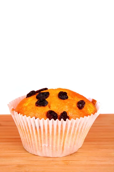 Muffin with raisins on wooden surface isolated on white — Stock Photo, Image