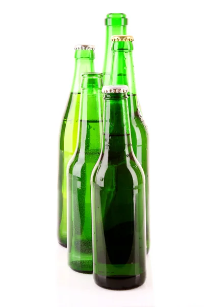 Muchas botellas de cerveza aisladas en blanco — Foto de Stock