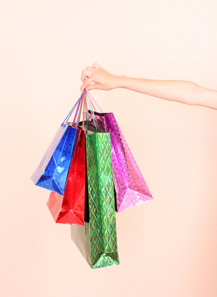 A woman hand holding many colorful shopping bags