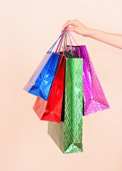 Kobieta ręki trzymającej wielu kolorowe torby na zakupy — Zdjęcie stockowe