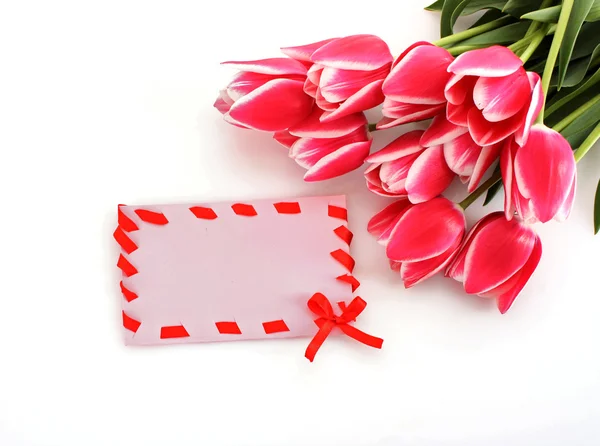 Kytice tulipánů a pohlednice na bílém pozadí — Stock fotografie