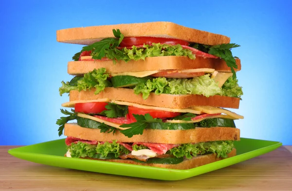 Grande sanduíche no fundo azul — Fotografia de Stock
