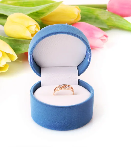 Anel de noivado de ouro na caixa no fundo das flores — Fotografia de Stock