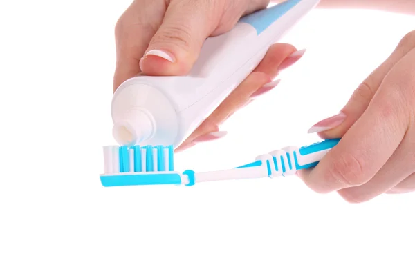 Pasta de dente e escova na mão sobre fundo branco — Fotografia de Stock