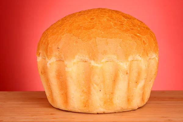 Pão de trigo fresco sobre fundo vermelho — Fotografia de Stock