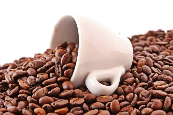 Lille hvid kop kaffe med kaffekorn på kornbaggrund - Stock-foto