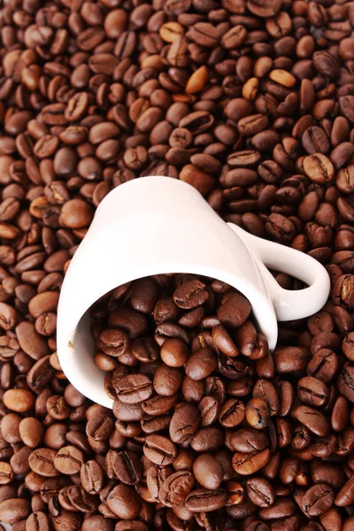 Маленькая белая чашка кофе с зерном на фоне зерна — стоковое фото