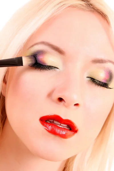 Schöne junge blonde Frau mit hellem Make-up und Pinsel auf w — Stockfoto