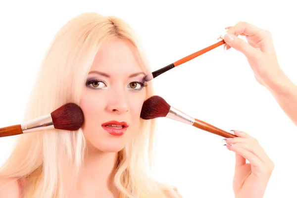 Schöne junge blonde Frau mit hellem Make-up und viele brushe — Stockfoto