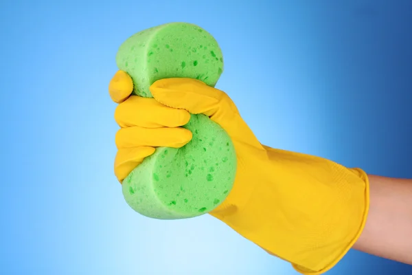 Hand bär en arbetande handske och innehar stor svamp — Stockfoto