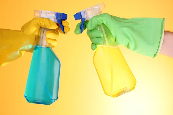 Dos manos con botella de spray en amarillo — Foto de Stock