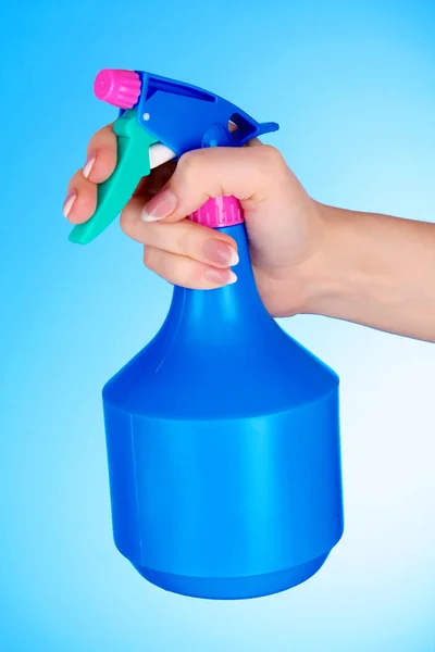 Manos con spray sobre fondo azul — Foto de Stock