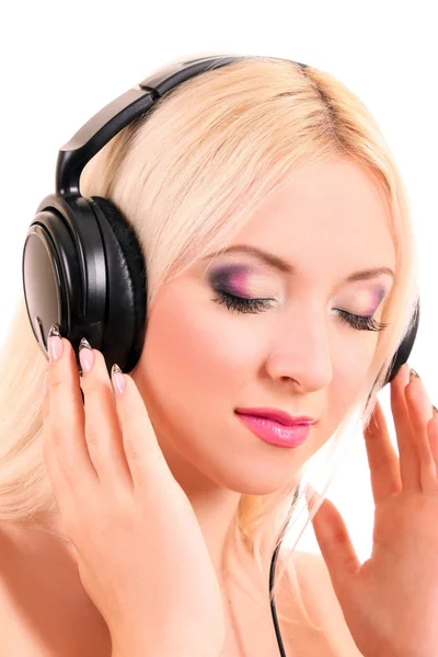 Schöne junge blonde Frau mit hellem Make-up Musik hören — Stockfoto