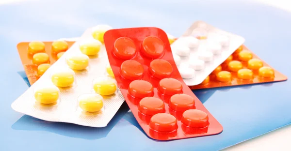 Píldoras de la medicina paquete pila primer plano sobre fondo rojo —  Fotos de Stock