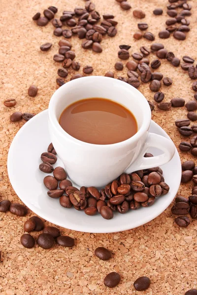 Petite tasse blanche de café avec grain de café sur fond brun — Photo