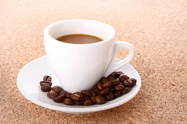 Piccola tazza di caffè bianco con chicco di caffè su backgrou marrone — Foto Stock