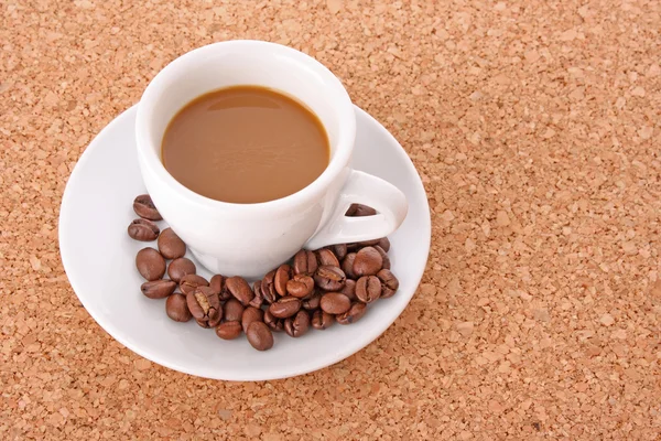 Petite tasse blanche de café avec grain de café sur fond brun — Photo