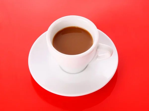 लाल पृष्ठभूमि पर कॉफी के साथ छोटा सफेद कप — स्टॉक फ़ोटो, इमेज