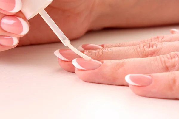 Mooie vrouw handen met Frans manicure op witte achtergrond — Stockfoto