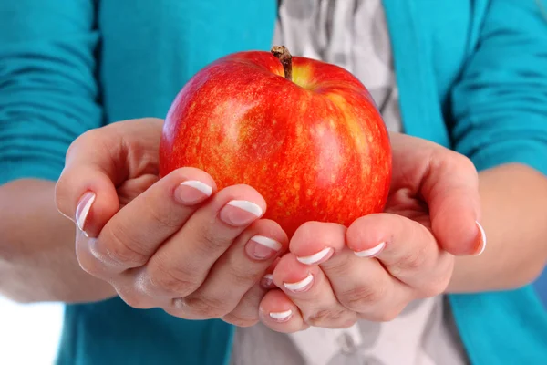 Ein Apfel auf der Hand auf blauem Hintergrund — Stockfoto