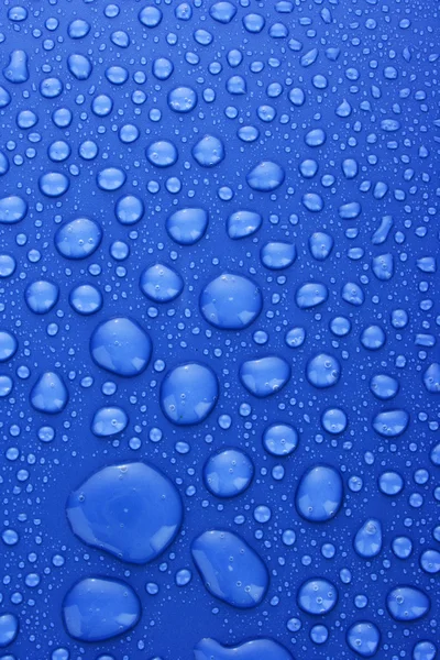 Синя вода падає на тло з великими і малими краплями — стокове фото