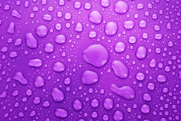 Violette Wassertropfen Hintergrund mit großen und kleinen Tropfen — Stockfoto