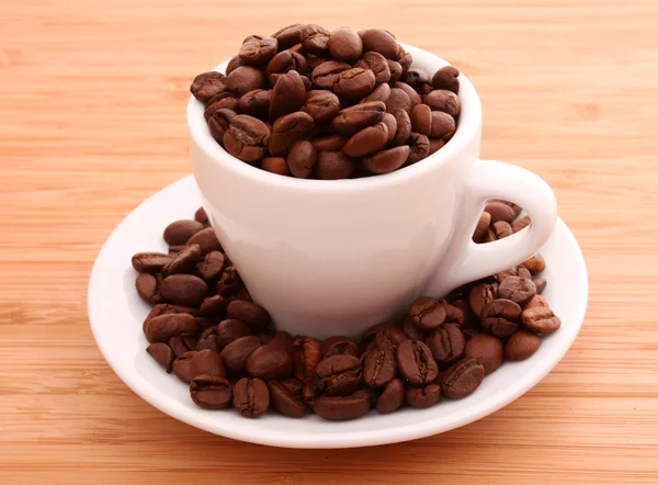 Grãos de café e uma xícara isolada no brawn — Fotografia de Stock