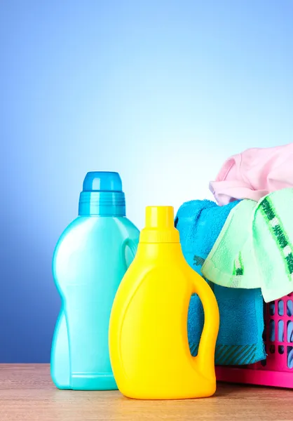 Toalhas coloridas e detergente líquido sobre azul — Fotografia de Stock