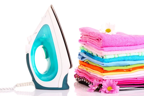 Pile of colorful clothes and electric iron over white backgroun — Stock Photo, Image