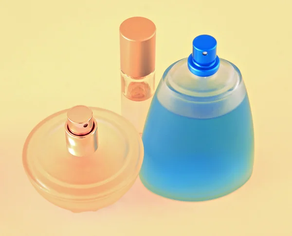 Bottle of perfume and camomile on yellow background — Stock Photo, Image