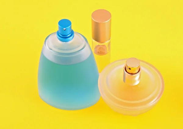 Bottiglia di profumo e camomilla su fondo giallo — Foto Stock