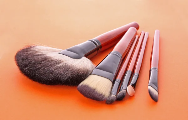 Kozmetik turuncu arka planda fırçalar — Stok fotoğraf
