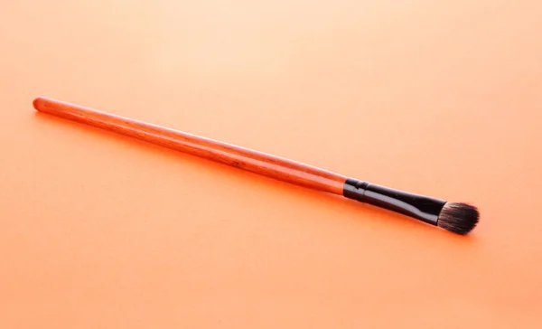 Pennello cosmetico sullo sfondo arancione — Foto Stock