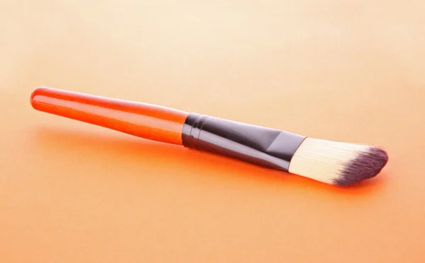 Cepillo cosmético sobre fondo naranja — Foto de Stock
