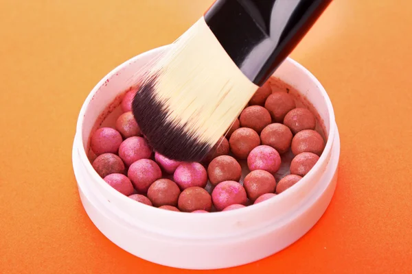 Kozmetik fırça ve rouge turuncu zemin üzerine — Stok fotoğraf