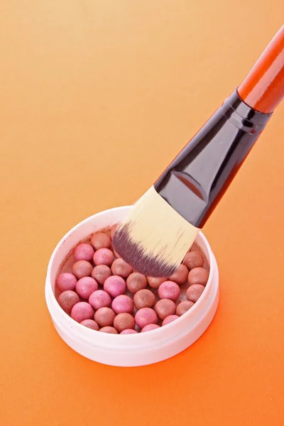 Spazzola cosmetica e rouge sullo sfondo arancione — Foto Stock