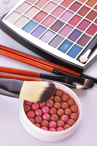 Spazzole cosmetiche pennello, ombretti e rouge sulla ba bianca — Foto Stock