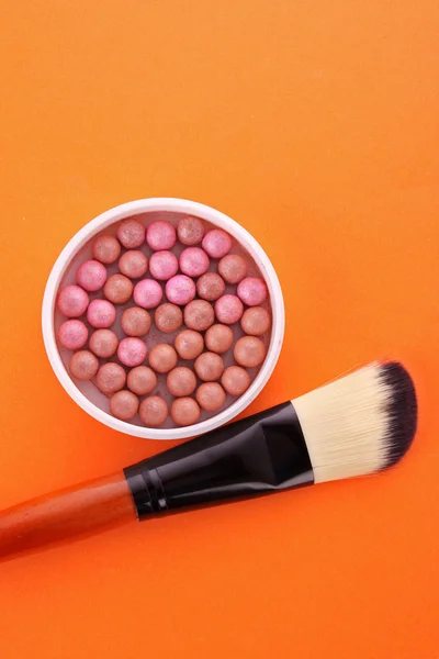 Cepillo cosmético y colorete en el fondo naranja —  Fotos de Stock