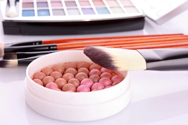 Escovas cosméticas escova, sombras de olhos e rouge na parte traseira branca — Fotografia de Stock