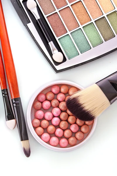 Kosmetikborstar borste, ögonskuggor och rouge på orange b — Stockfoto