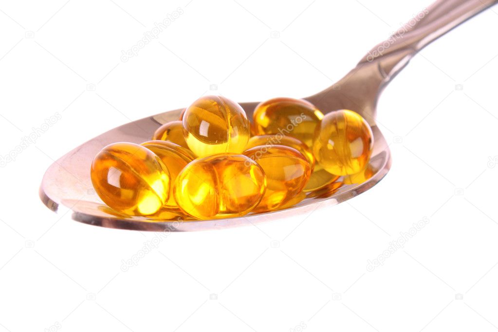 A spoon full of Fish Oil Capsules isolated on white