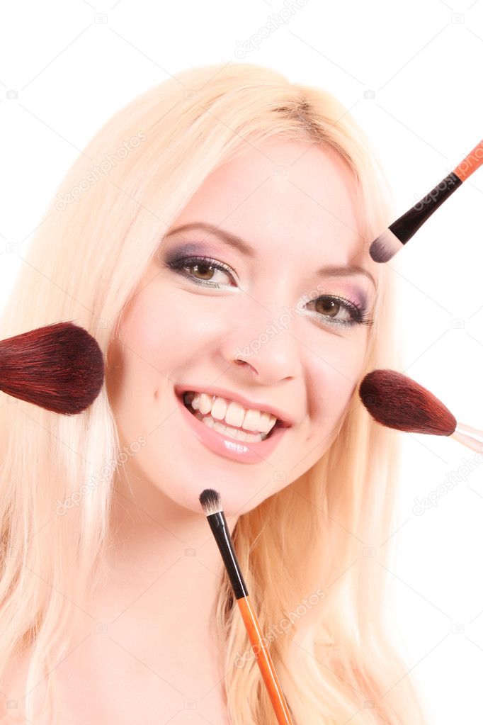 Beautiful young blonde woman with bright make-up and many brushe