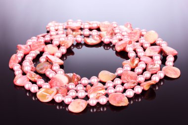 Pink pearl necklaces and seashells on a gray background clipart