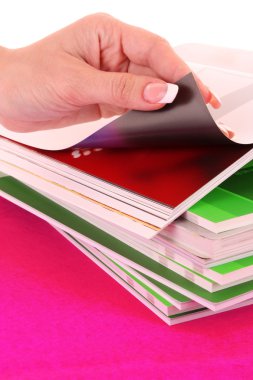 Hand browsing through stack of magazines clipart