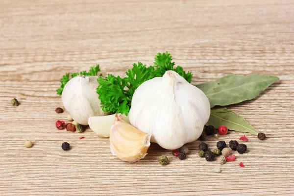 Spices, garlic and parsley on a wooden background — Stock Photo, Image