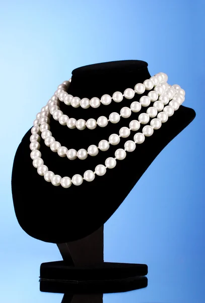 Collar de perlas en un maniquí sobre un fondo azul — Foto de Stock