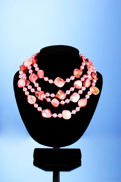 Collana di perle rosa e conchiglia su sfondo blu — Foto Stock
