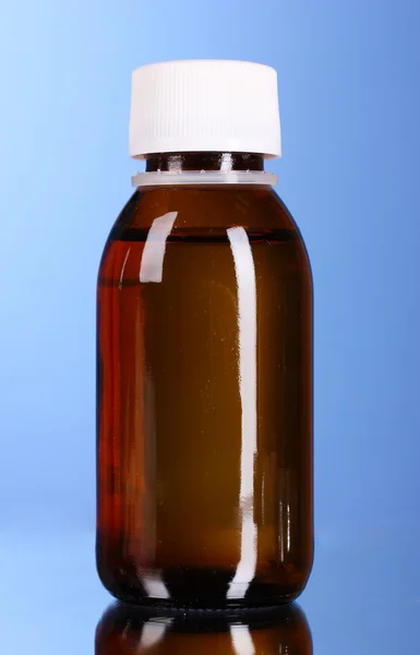 Medicina in bottiglia con sfondo blu — Foto Stock