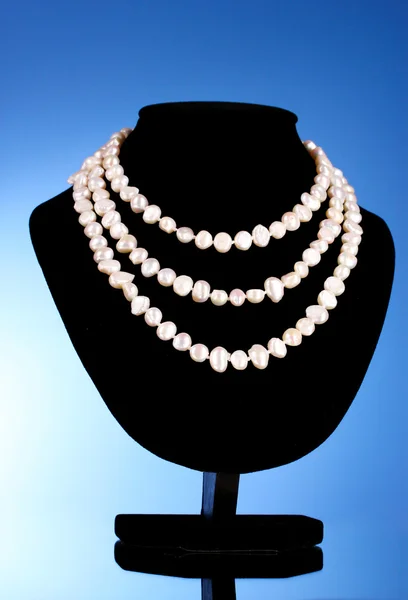 Un collar de perlas sobre un fondo azul —  Fotos de Stock